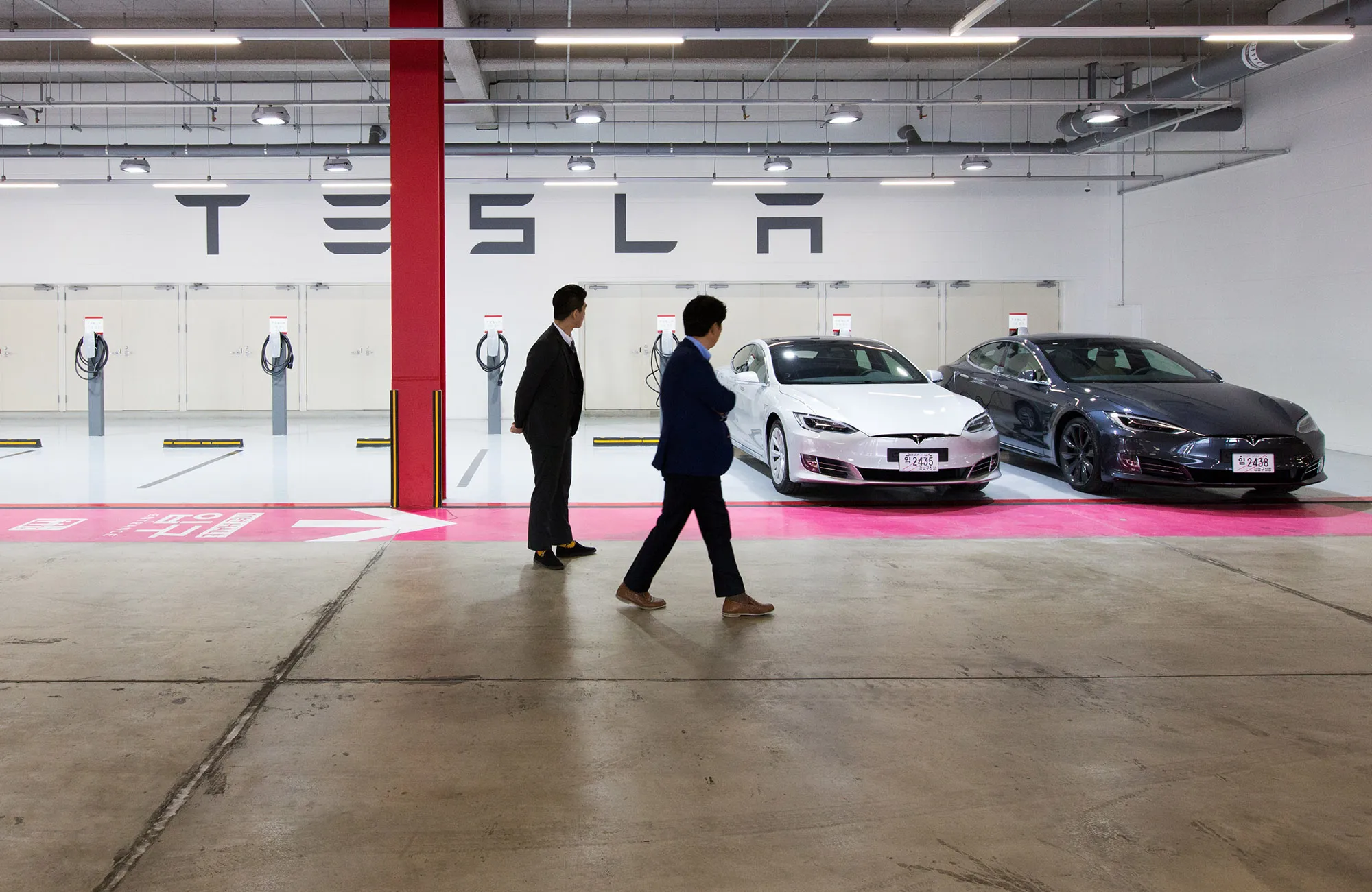 Customers look at Tesla Model S 90D electric vehicles.