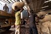Workers unload sacks of cocoa beans at a rebagging facility in San-Pedro, Ivory Coast.