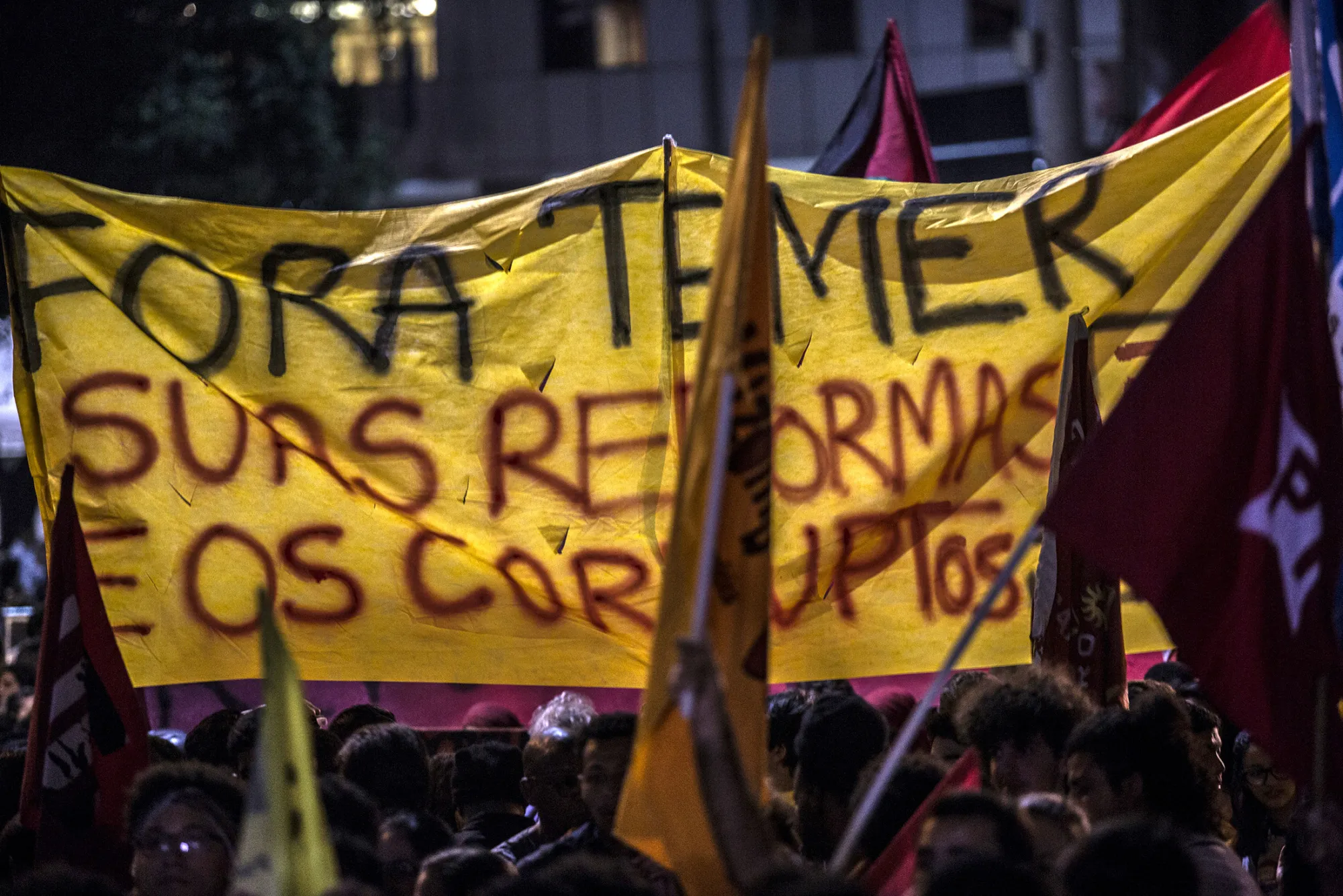 Demonstrators hold a large banner that reads 'Out Temer And All Your Reforms And Corruption' during a general strike against labor and retirement reforms in Rio de Janeiro, Brazil, on June 30, 2017.
