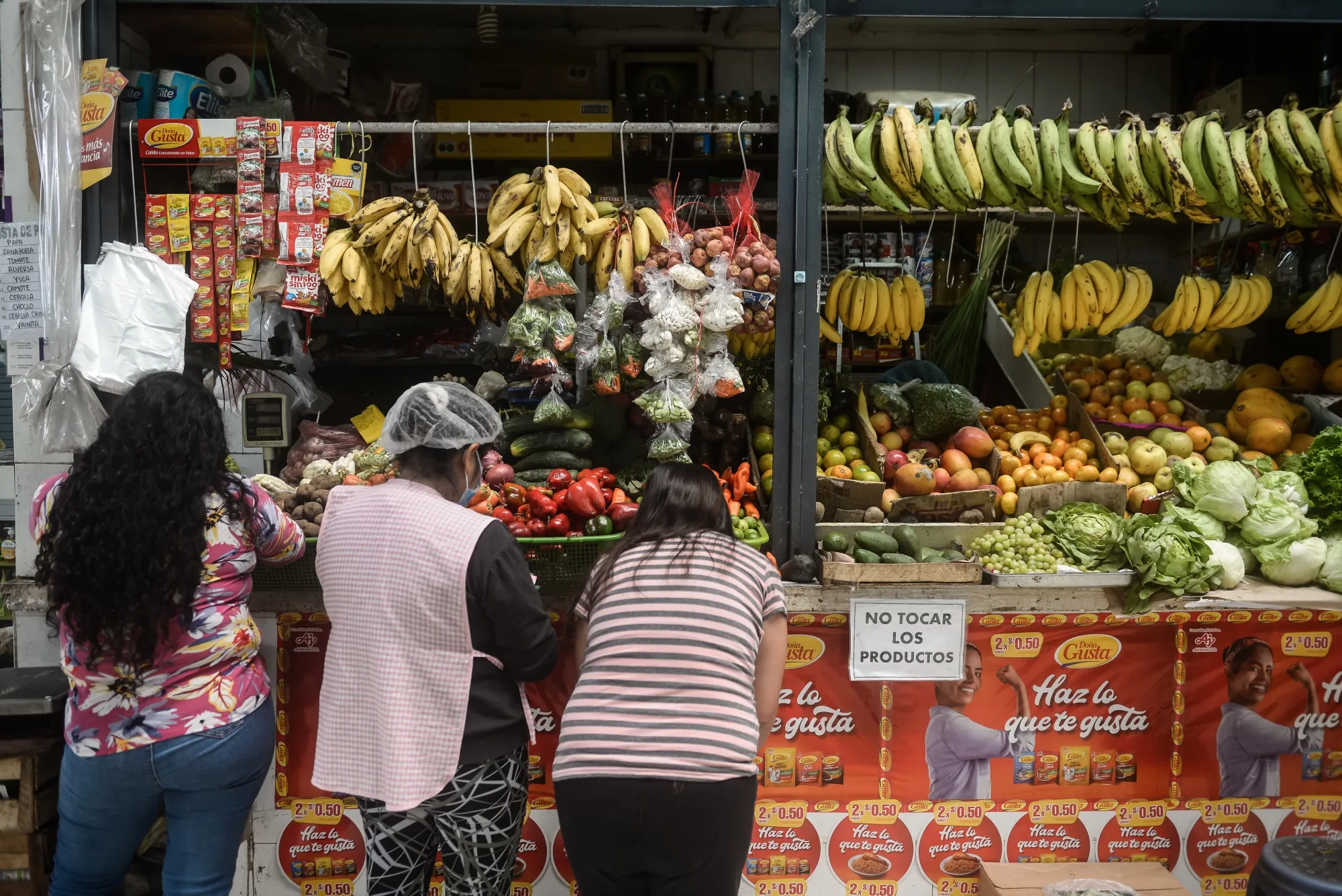 Shoppers browse produce at a market in Lima, Peru.