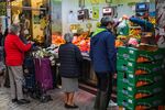 Customers wait to be served at a fresh produce stall in a market in Madrid.