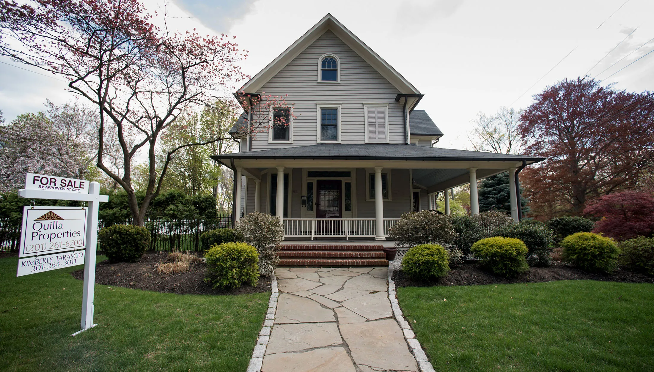 A 'For Sale' sign is displayed outside of a house in Oradell, New Jersey, U.S., on Friday, May 1, 2015. The number of Americans who signed contracts in March to buy previously owned homes climbed after the biggest increase in more than four years, a sign for further progress in the housing recovery.
