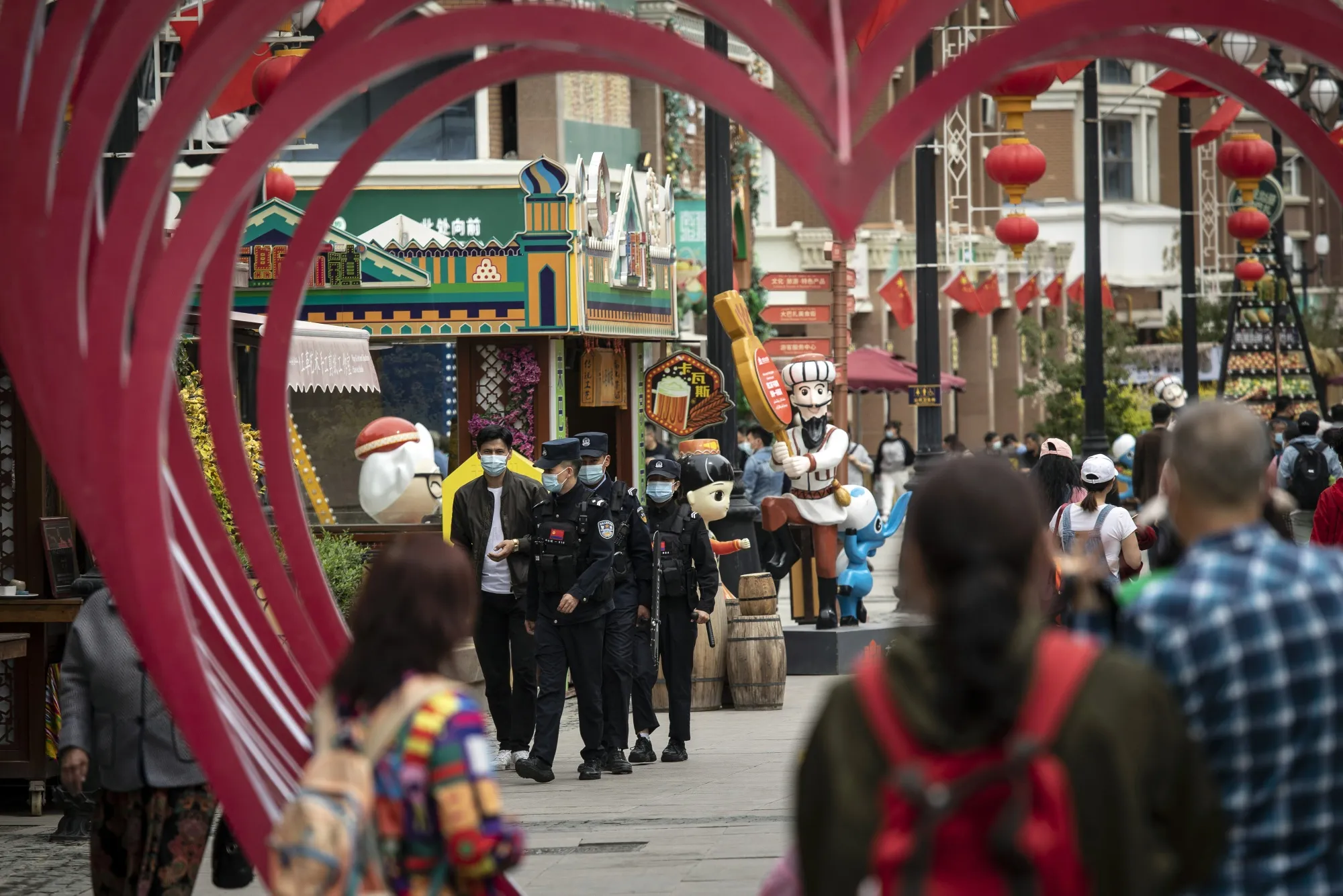 A squad of police officers patrol the Xinjiang International Grand Bazaar in Urumqi, Xinjiang province.