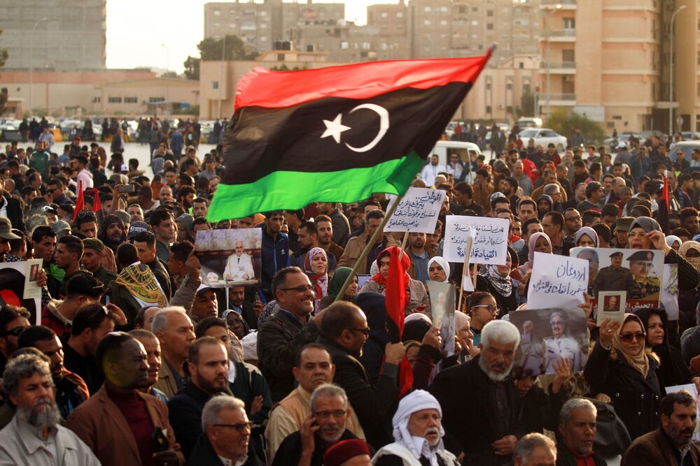 Supporters of Khalika Haftar wave a national during a demonstration in Libya.