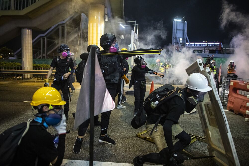 Demonstrators use slingshots to fire projectiles towards riot police on Gloucester Road during a protest in the Causeway Bay district of Hong Kong, China.