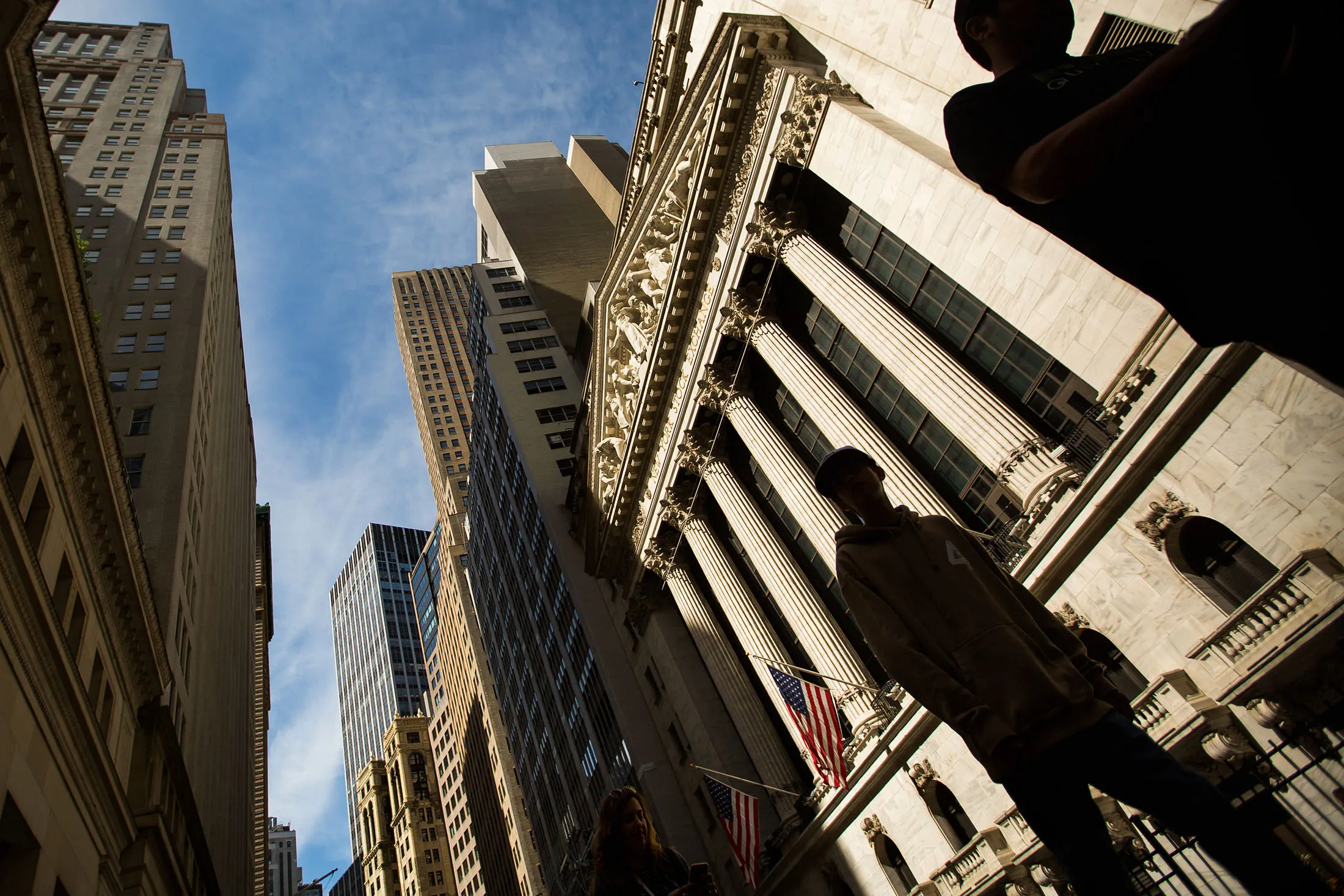 Pedestrians pass in front of the New York Stock Exchange (NYSE) in New York, U.S., on Friday, June 9, 2017. U.S. stocks reached intraday records and the dollar rose, but the British pound tumbled as the U.K.'s ruling Conservative Party lost its parliamentary majority, plunging the country into uncertainty just days before Brexit negotiations were due to start.

