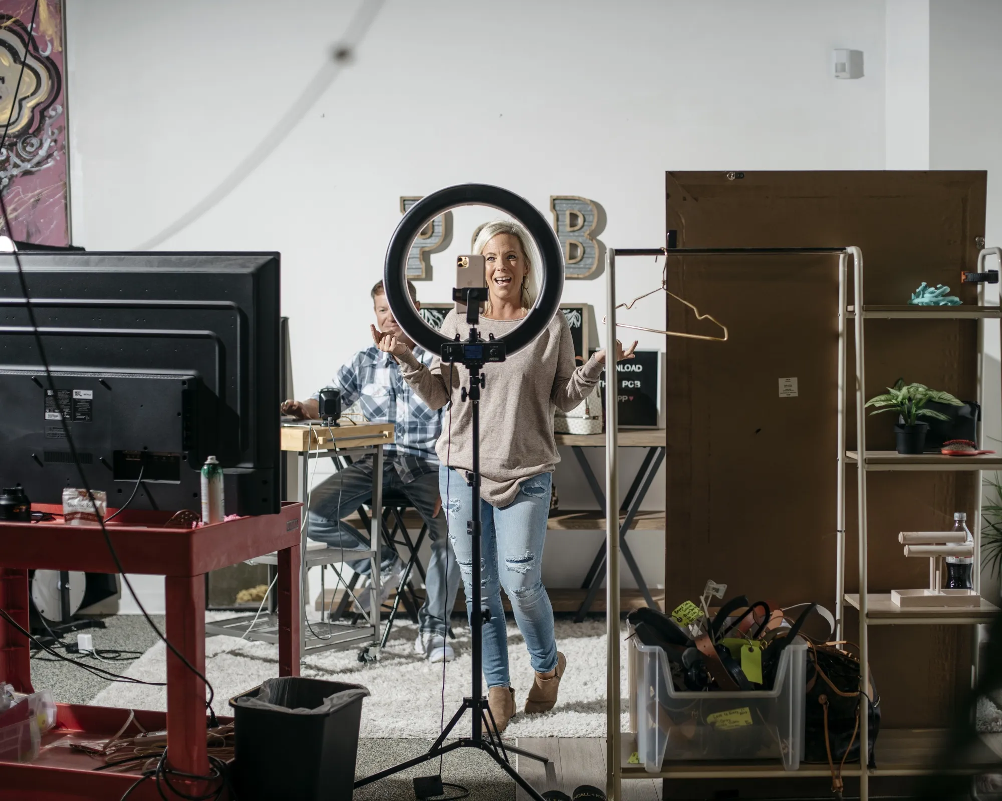 Sheri Hensley, co-owner of Pink Coconut Boutique, models clothes during a&nbsp;livestream from Olive Branch, Mississippi. She and her husband, Mic (seated), have doubled their company’s sales thanks to a boom in viewership during Covid-19.