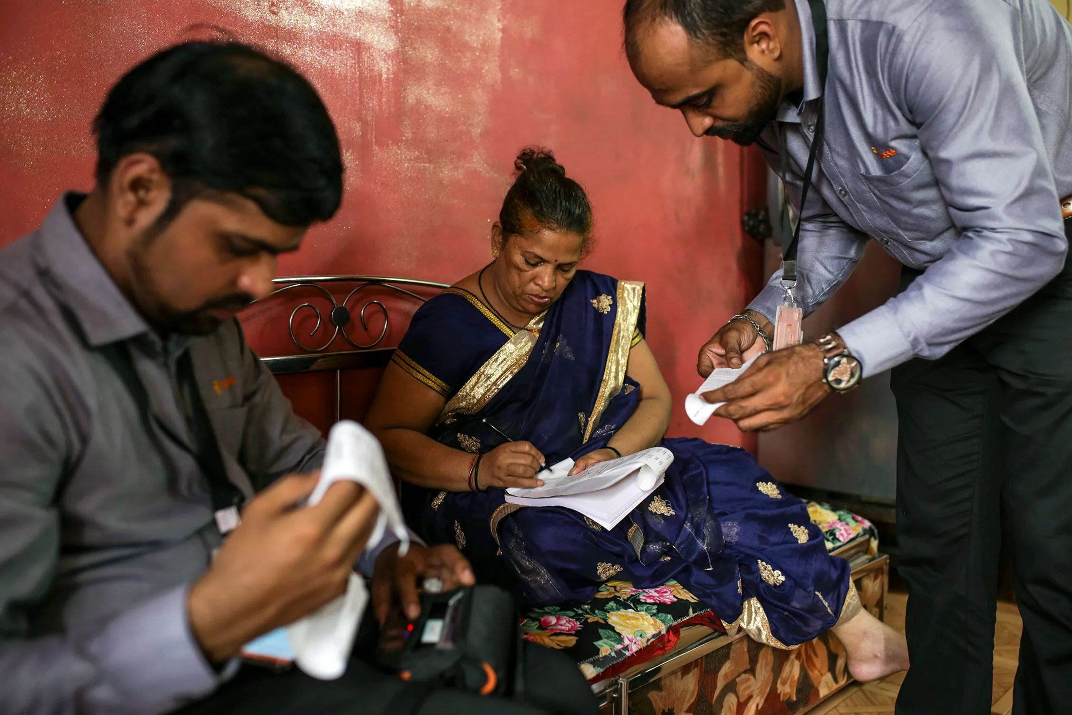 Rupeek agents process a gold loan at a borrower’s home in Mumbai.