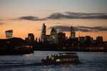 A tourist boat travels along the River Thames towards the City of London skyline in London, U.K., on Wednesday, Oct. 28, 2015. In its monthly consumer confidence index, GfK said a measure of Britons' outlook for the economy over the next 12 months dropped to minus 4 in October, the lowest reading this year.
