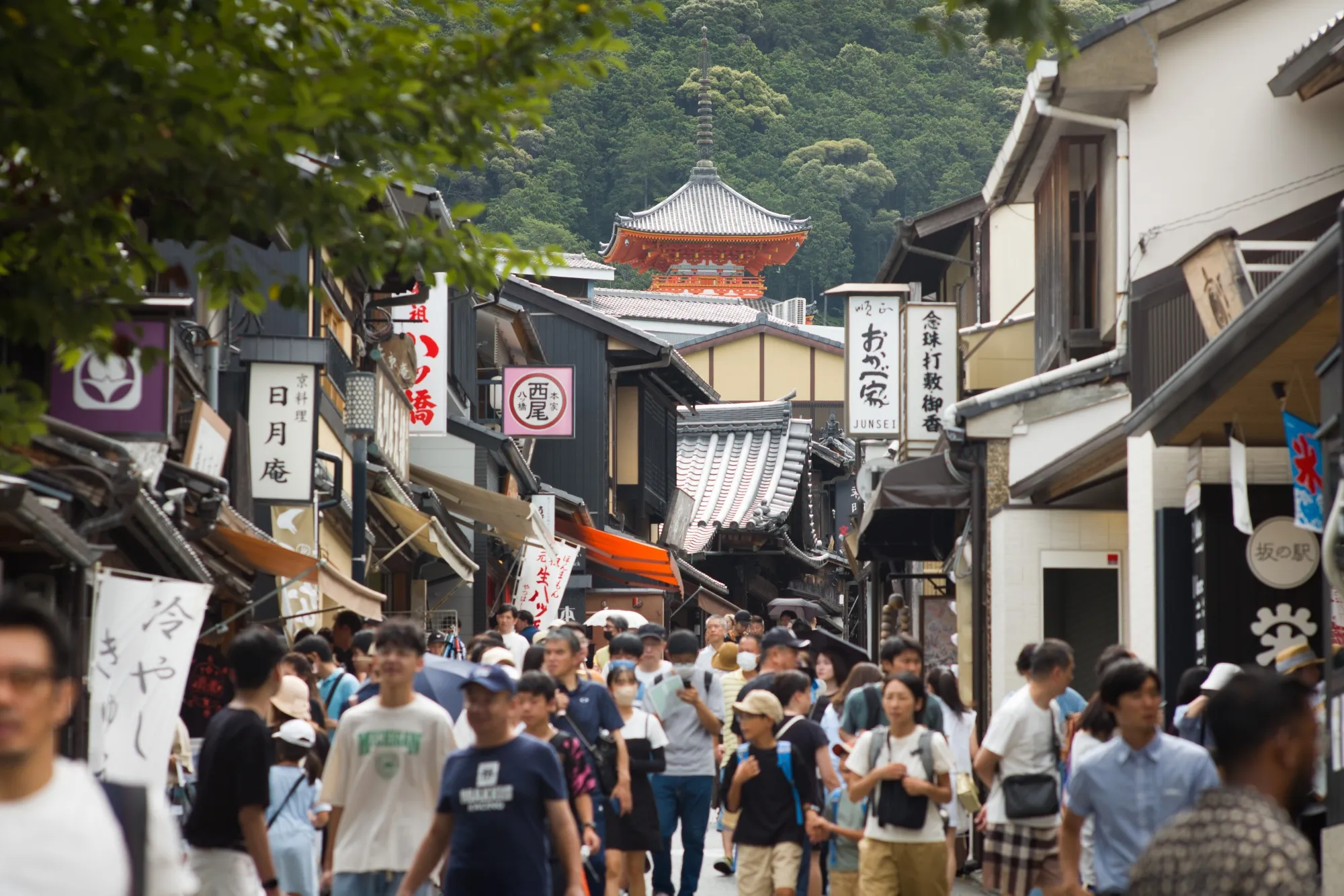Tourists walk along an approach to Kiyomizu temple in Kyoto, Japan.
