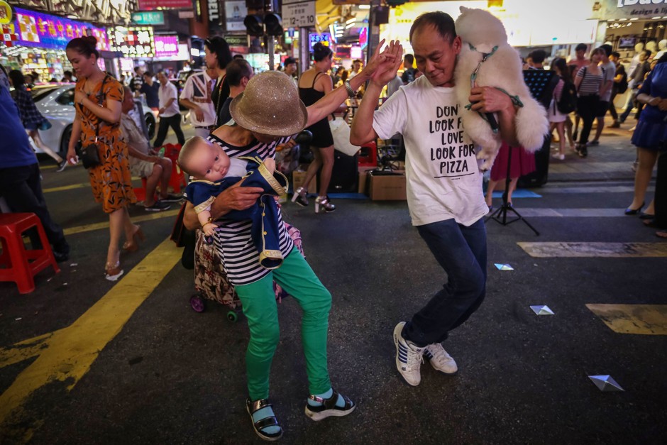 People dance along to a karaoke performance on Sai Yeung Choi Street. 