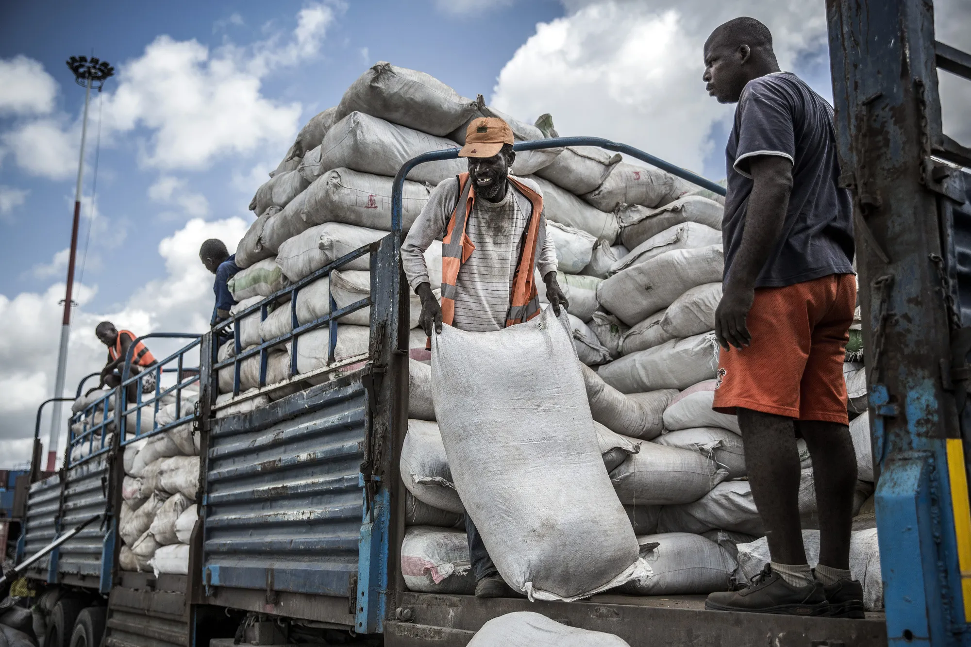 Dock workers unload sacks of goods from a truck in Kenya.