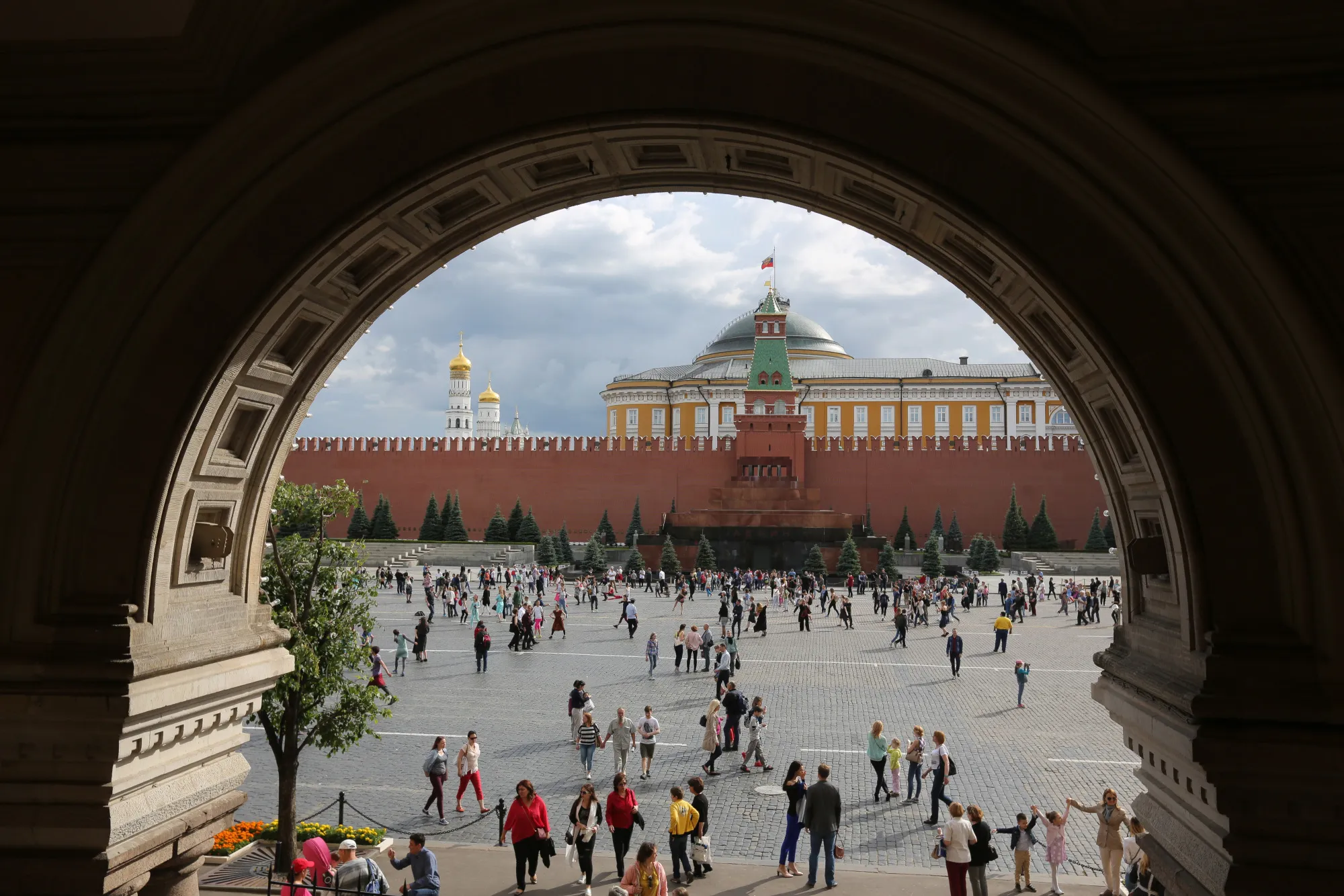 Tourists walk by The Kremlin in Moscow.