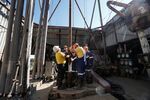 Workers position pipework on an oil drilling platform in Boryslav, Lviv region, Ukraine.