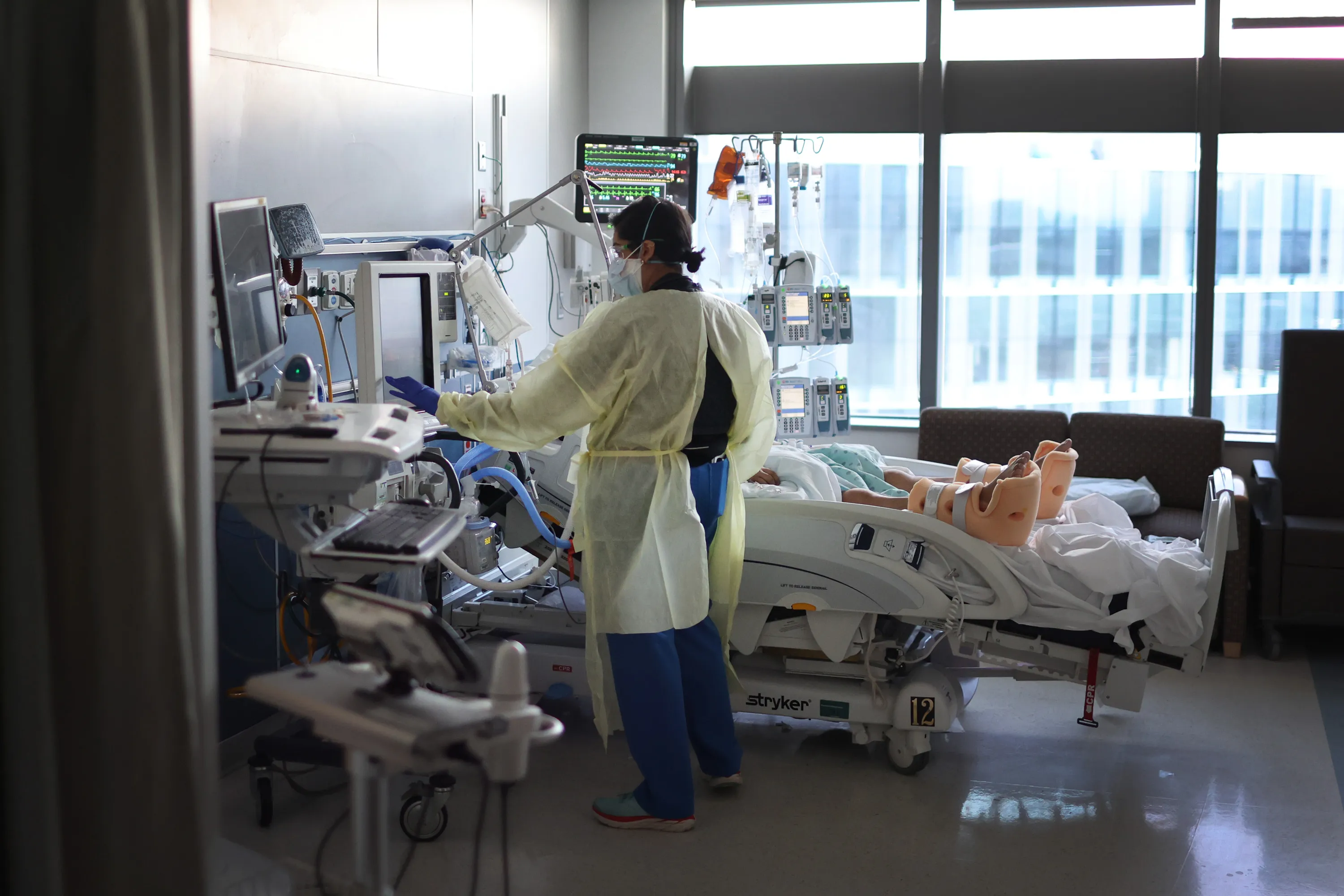 A respiratory therapist works with a COVID-19 patient in the ICU in Chicago in 2022.