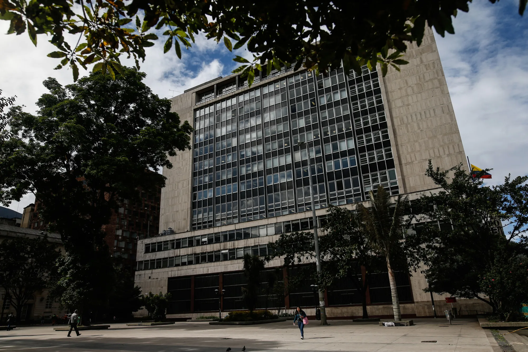 Pedestrians pass in front of the Central Bank of Colombia in Bogota, Colombia.
