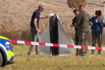 Officials secure parts of a downed drone in Wohyn, Poland, on Sept. 10.
