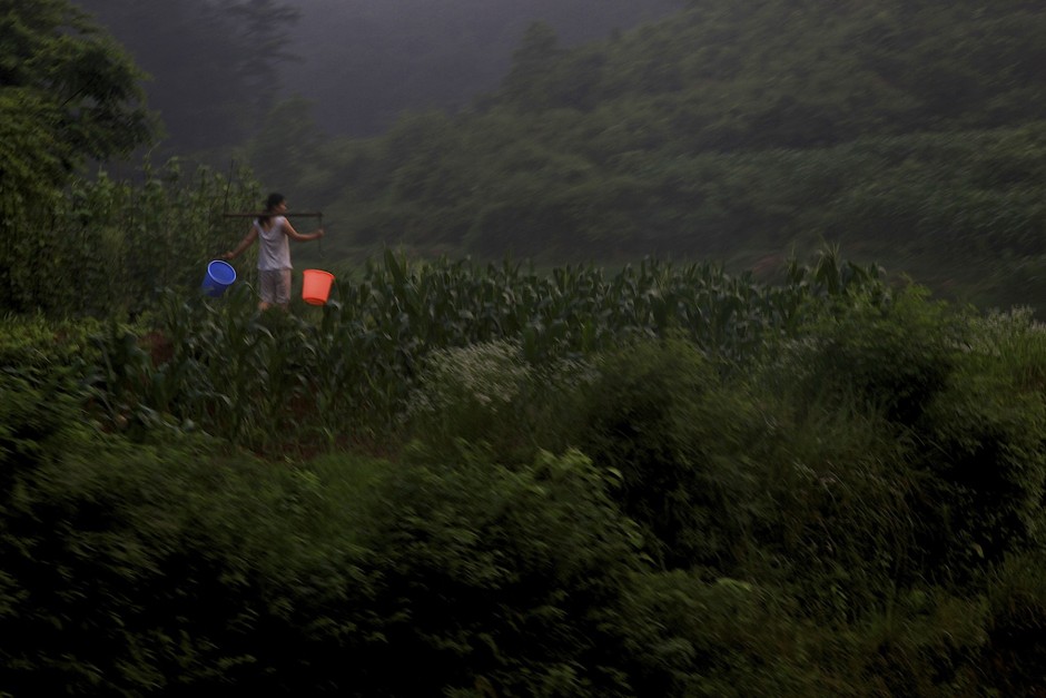 A woman makes her way to the fields in Hunan Province, located in south-central China