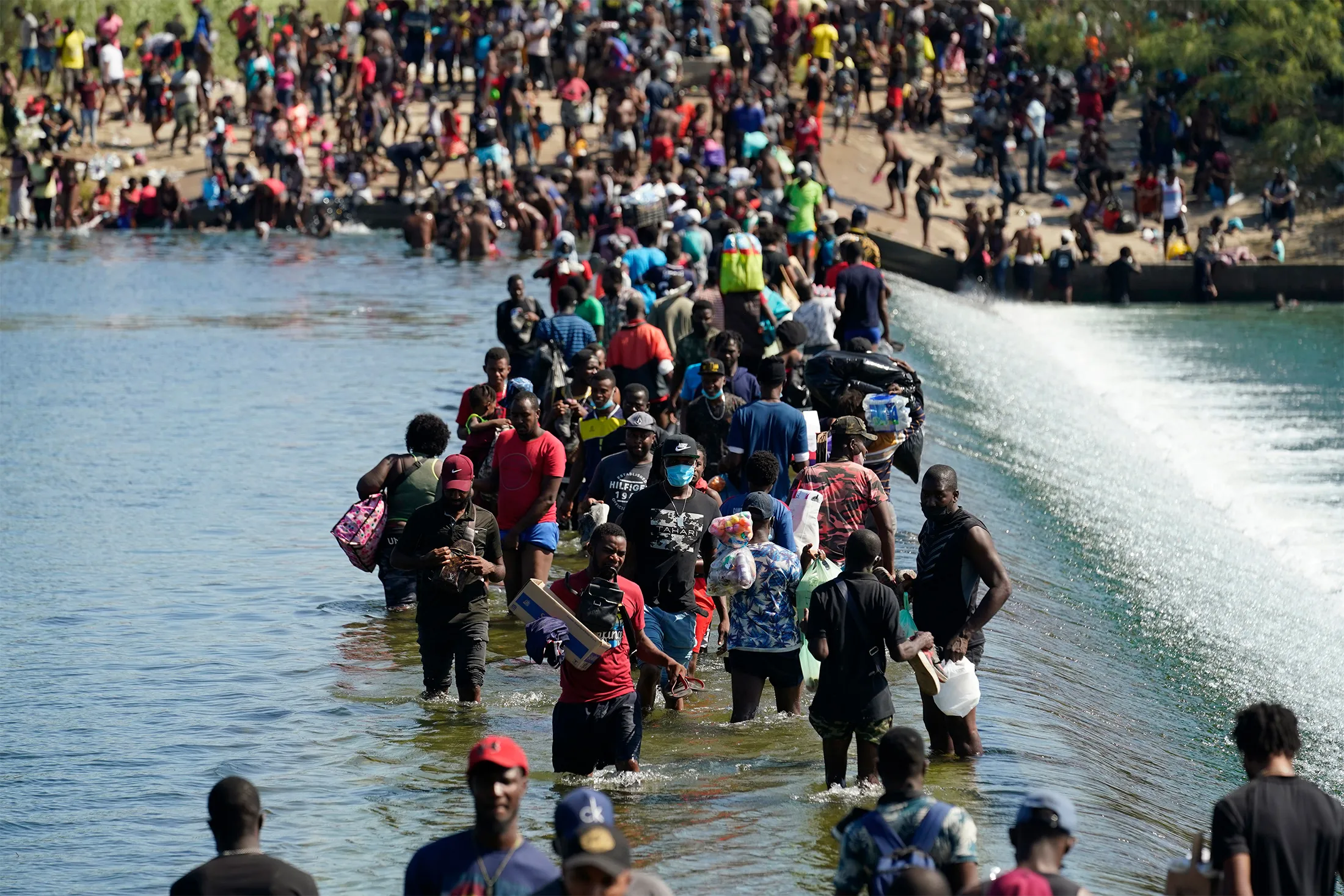 Haitian migrants use a dam to cross to and from the United States from Mexico, in Del Rio, Texas, on Sept., 17, 2021.