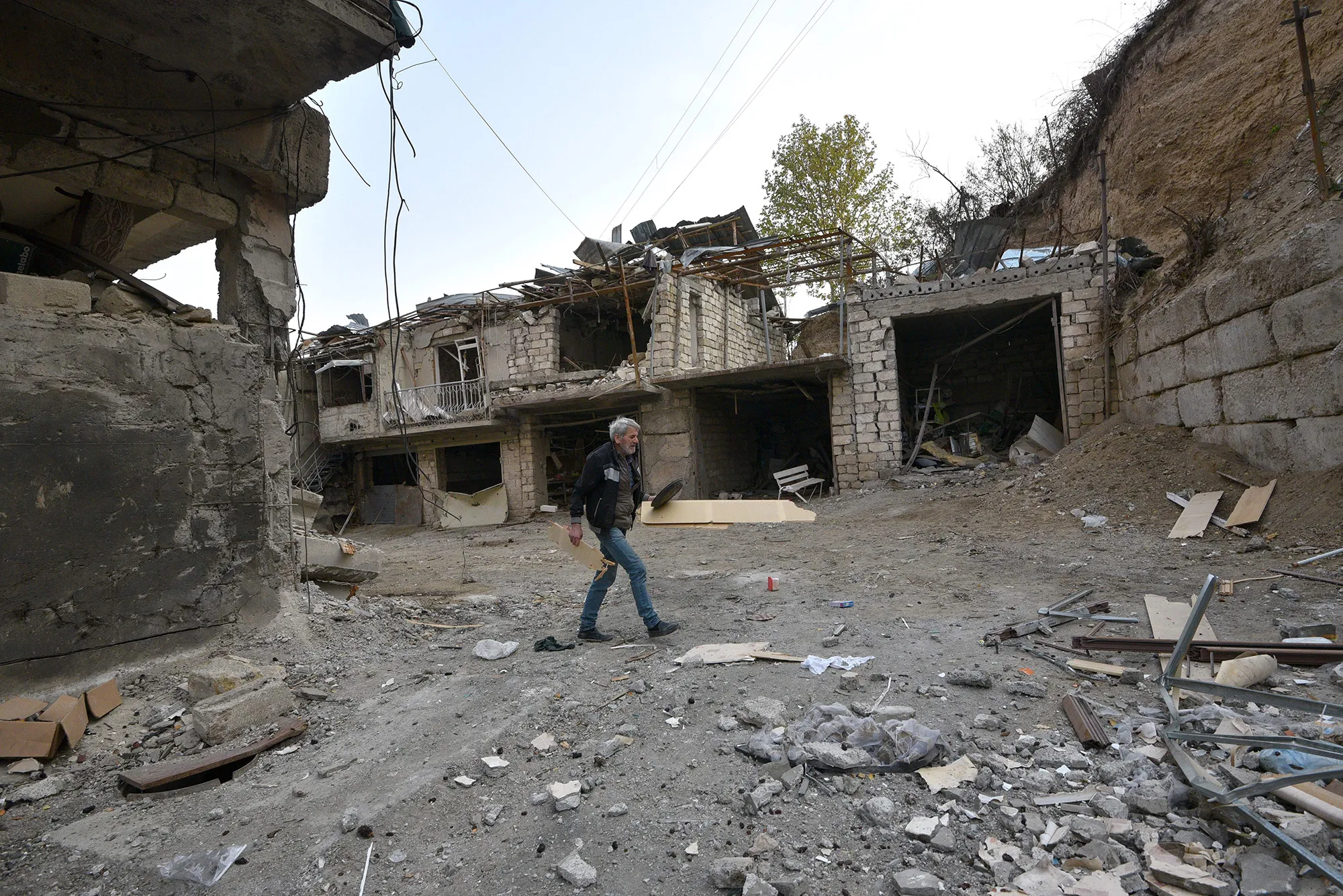 A man removes debris in a residential area damaged by shelling in Stepanakert on Nov. 3.