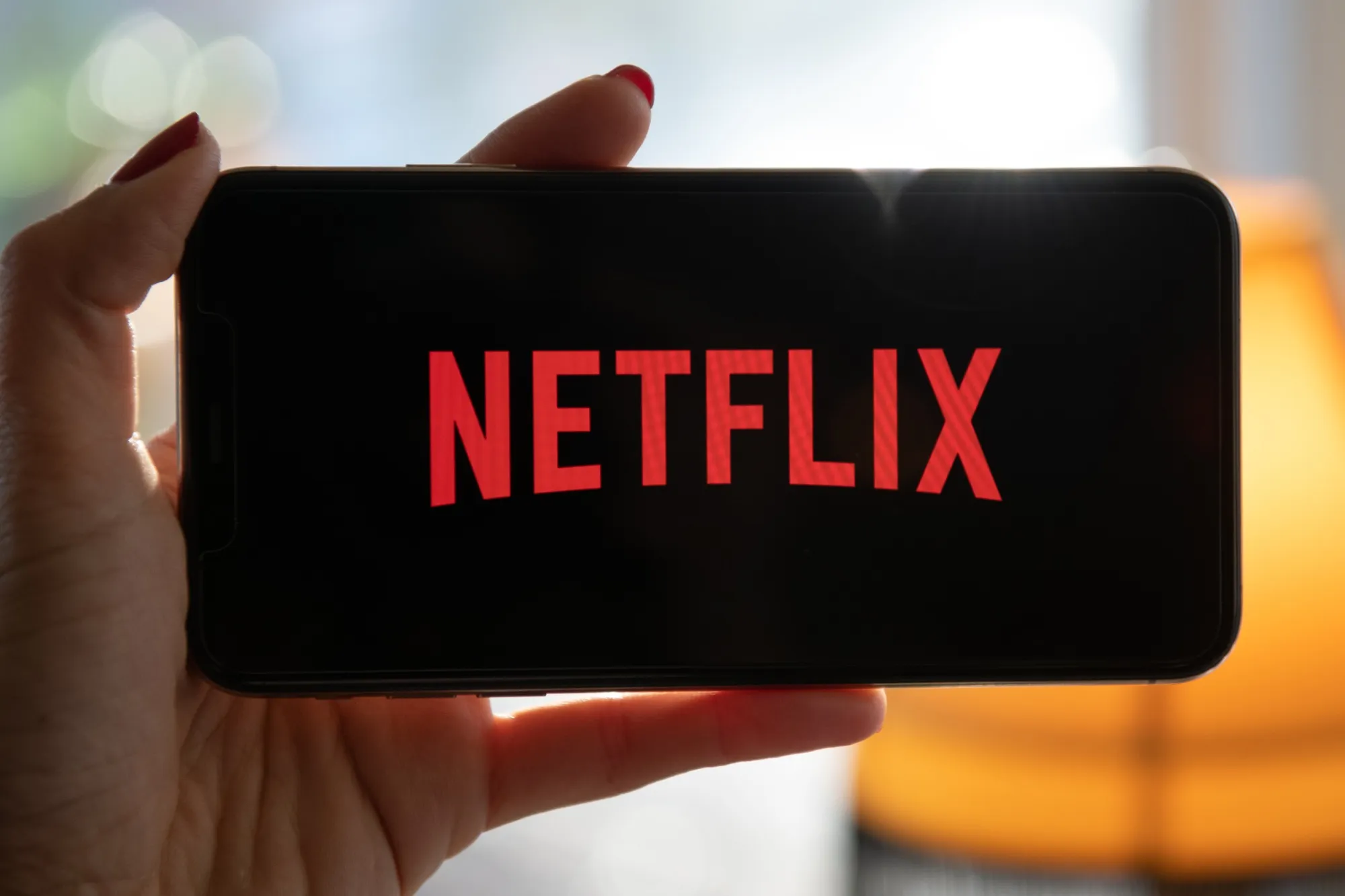 The Netflix Inc. logo on a smartphone arranged in Seattle, Washington, U.S., on Saturday, Jan. 23, 2021. Netflix Inc. ended its biggest year in company history with a bang, powering its stock to intraday and closing highs after adding more customers than expected and saying it no longer needs to borrow money to build its entertainment empire.