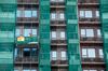 Worker labor from a construction platform at a residential building site in the Yuen Long district of the New Territories in Hong Hong, China, on Tuesday, July 23, 2019. A rally of more than 100,000 people in Hong Kong devolved into a night of violence on Sunday, with police firing tear gas after protesters gathered in front of China's liaison office in the city and defaced the national emblem. Masked men wearing white shirts and wielding batons, some suspected to be linked to triads, later attacked people in a metro station and mall in the mainland border town of Yuen Long.