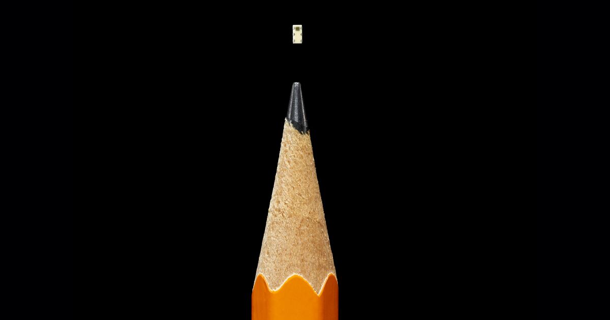 Ukuran chip dibandingkan dengan pensil.