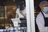 A worker wearing a protective mask uses a Square Inc. terminal inside a shop in Hudson, New York, U.S.