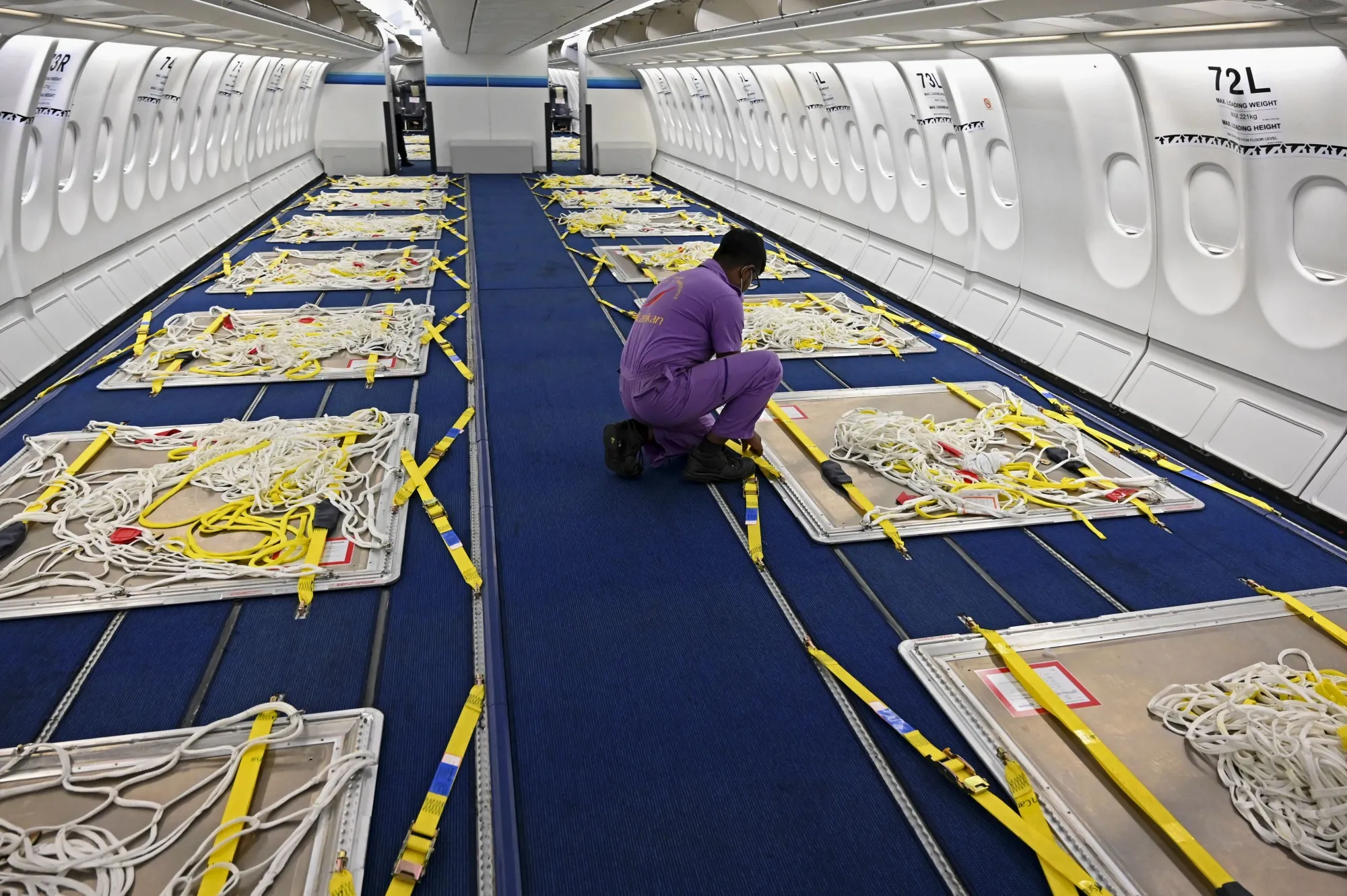 A Sri Lankan Airlines worker gives final touches to an Airbus A330 passenger aircraft, converted into a cargo carrier, in June 2020.