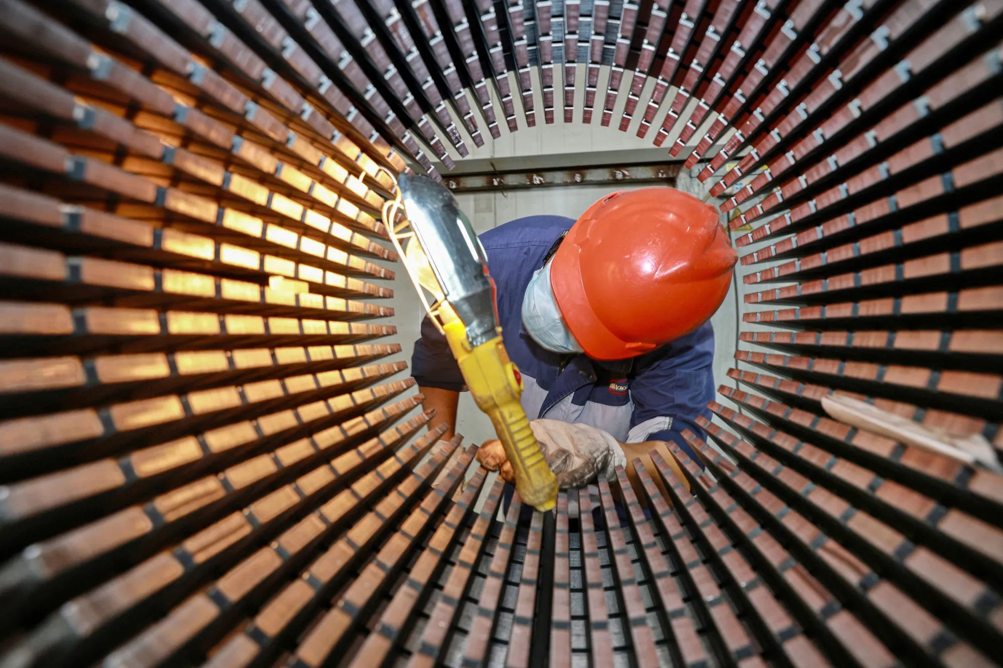 A worker checks a rotor core for wind turbines at a factory in Nantong, China.