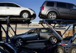 Workers unload a truck carrying new Honda automobiles at a dealership in Queens, New York.
