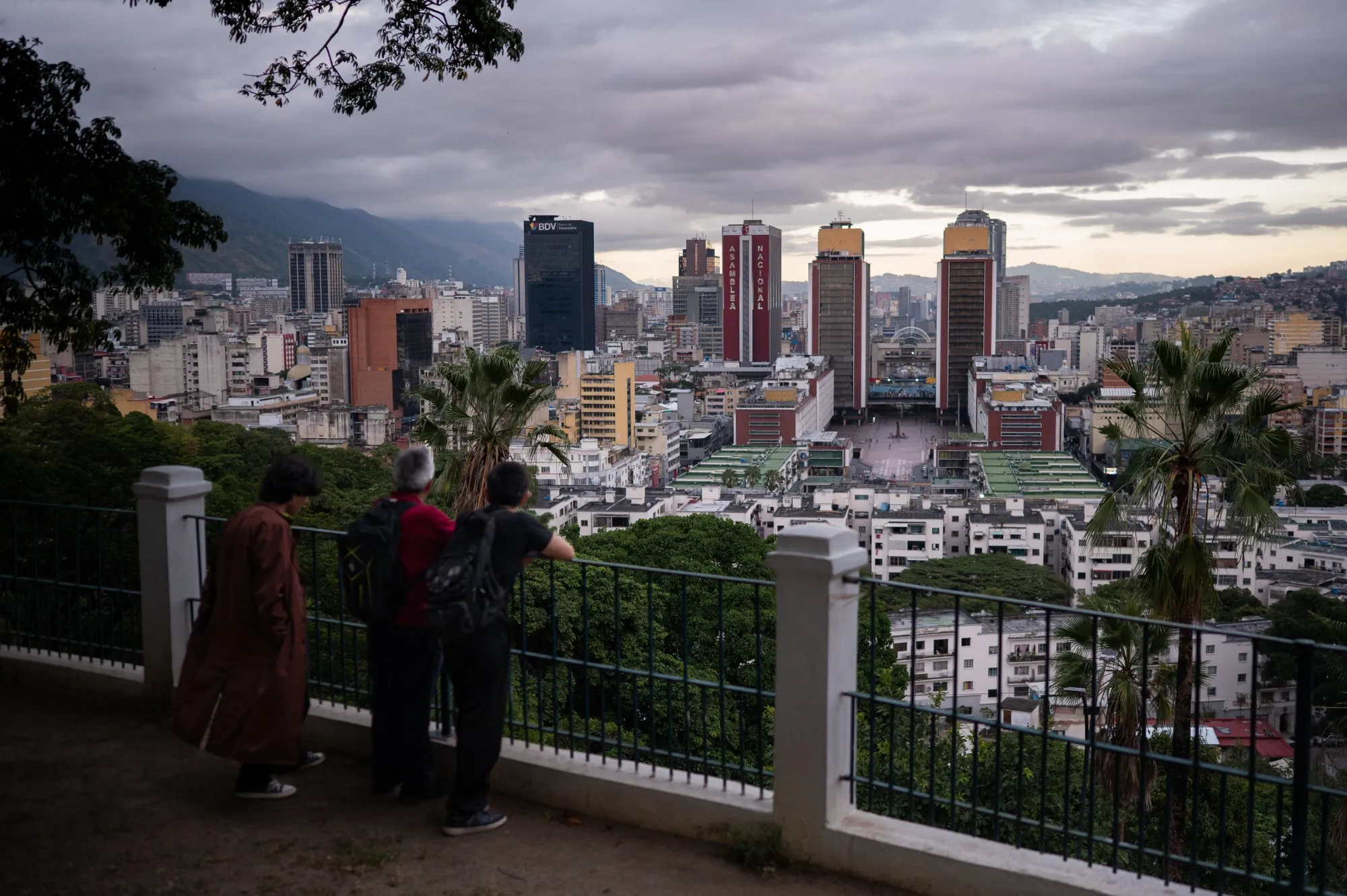Pedestrians look out from a viewpoint over the Simon Bolivar Towers, center right, and National Assembly building, center left, in Caracas, Venezuela, on&nbsp;Nov. 29.