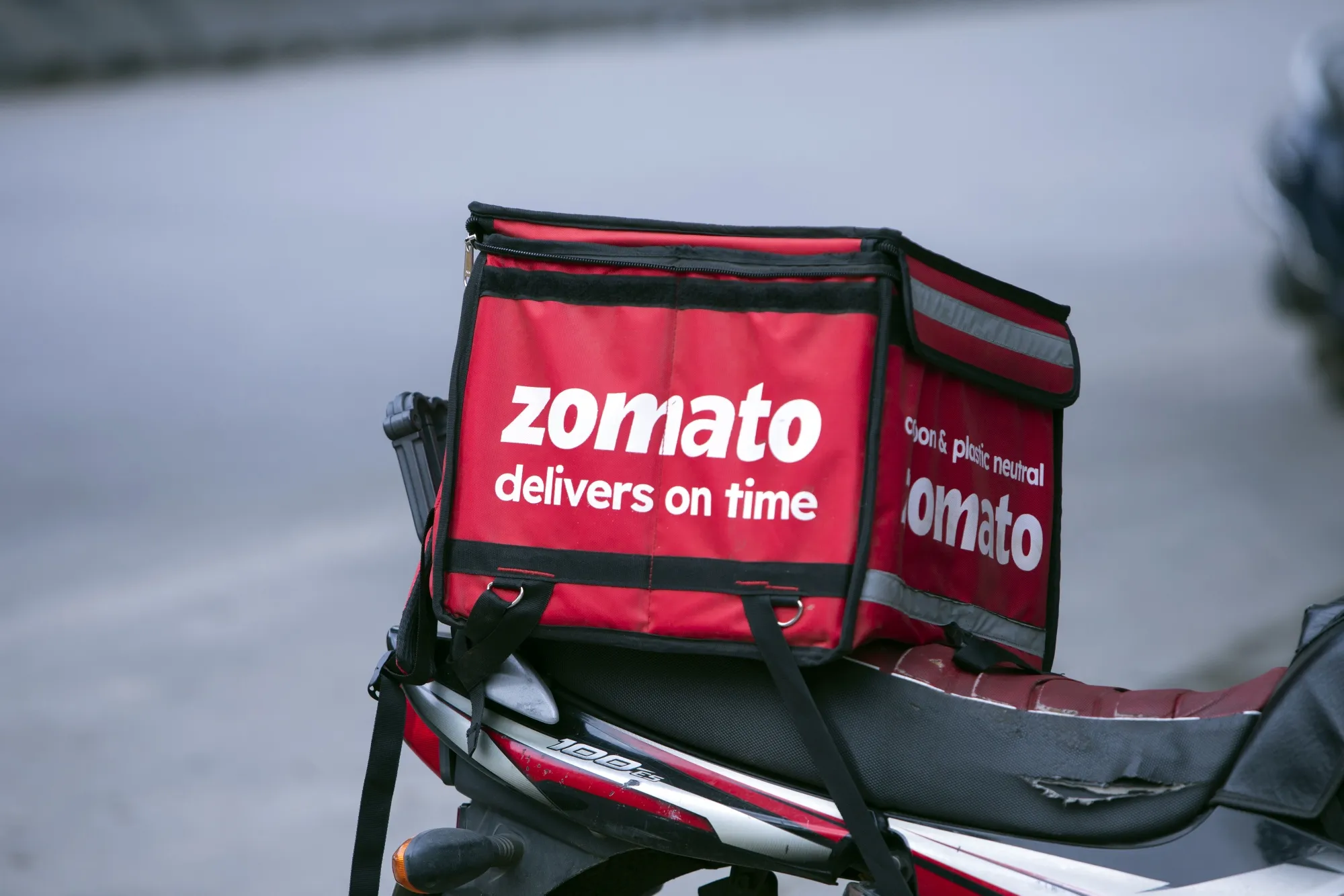 Signage for Zomato on a cooler bag at the back of a motorcycle in Bengaluru.