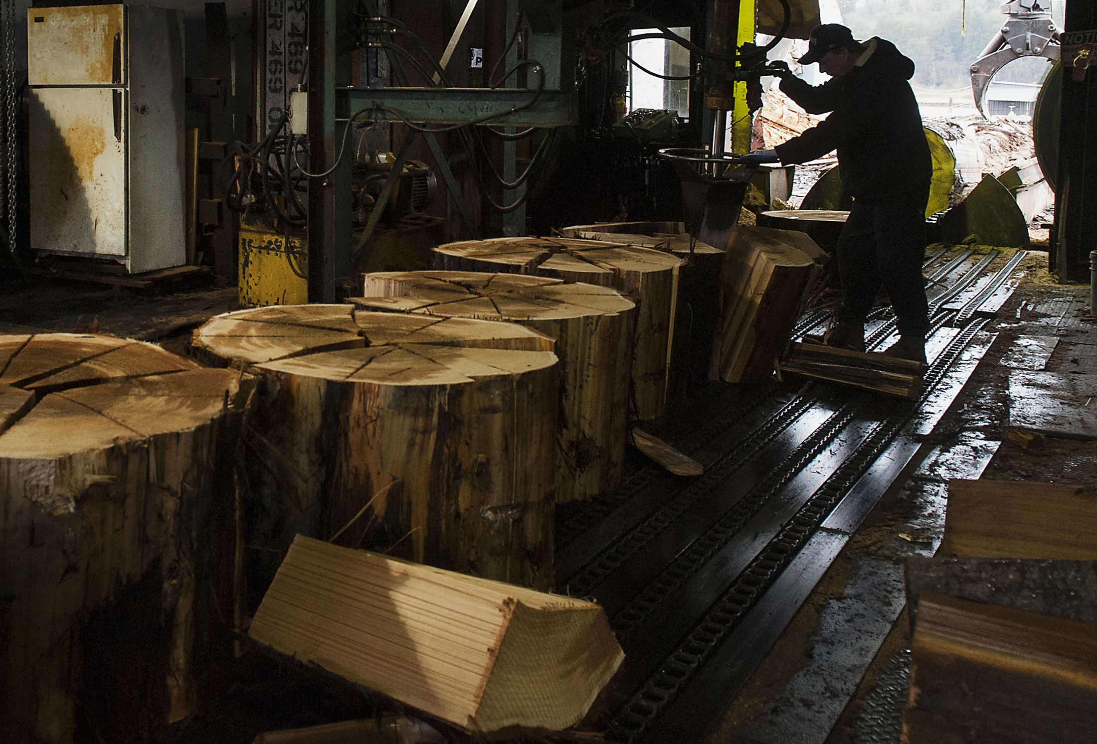 A worker splits cedar logs to manufacture shakes and singles at the S&amp;W Forest Products Ltd. facility in Maple Ridge, British Columbia, Canada.
