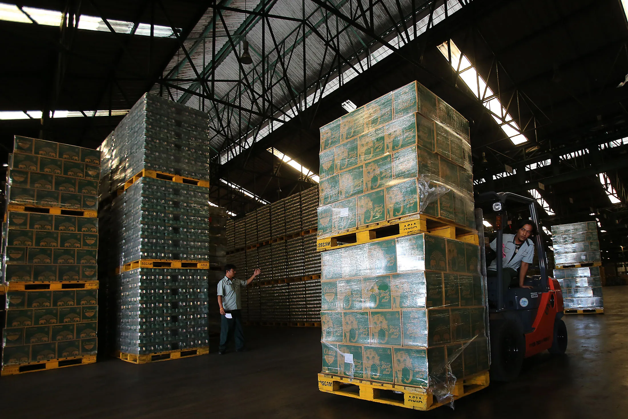 Workers prepare stacks of Chang beer in Ayutthya province.
