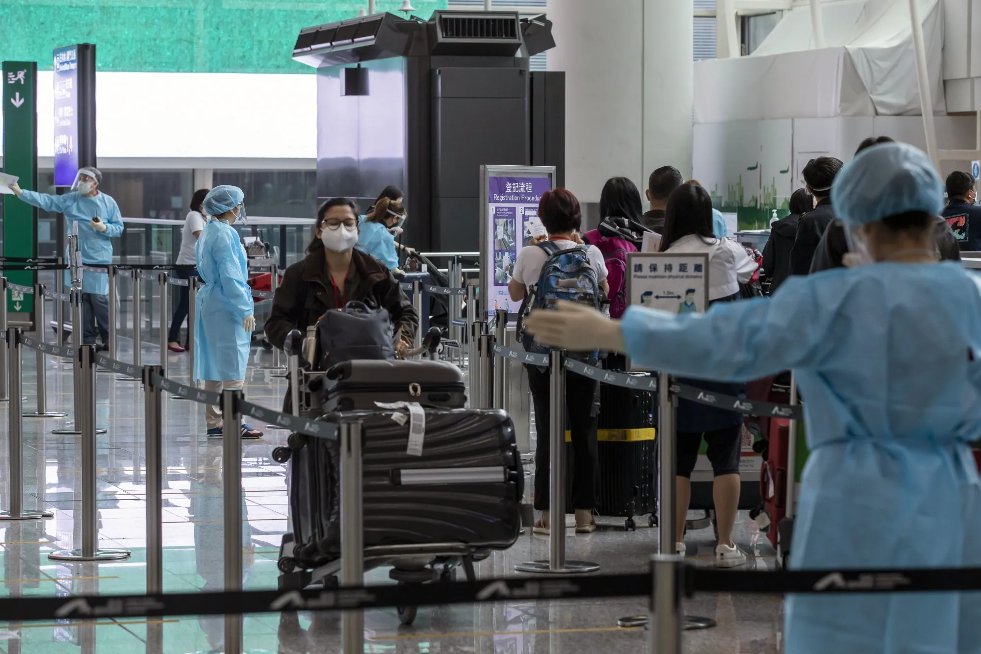 Travelers heading to quarantine in the arrival hall at Hong Kong International Airport.
