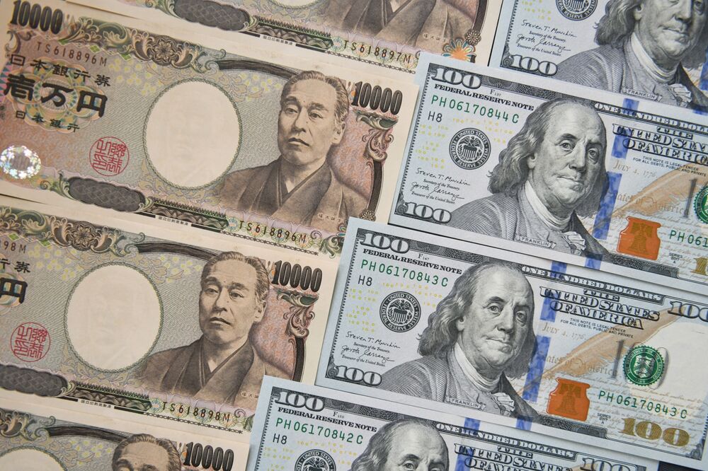 Japanese 10,000 yen, left, and US 100 dollar banknotes arranged for a photograph in Tokyo, Japan