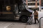 A United Parcel Service Inc. (UPS) driver wearing a protective mask pushes a cart towards their truck in Chicago, Illinois, U.S., on Monday, Nov. 30, 2020. 