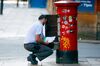 A postal worker for Royal Mail Plc empties a postbox in Manchester.