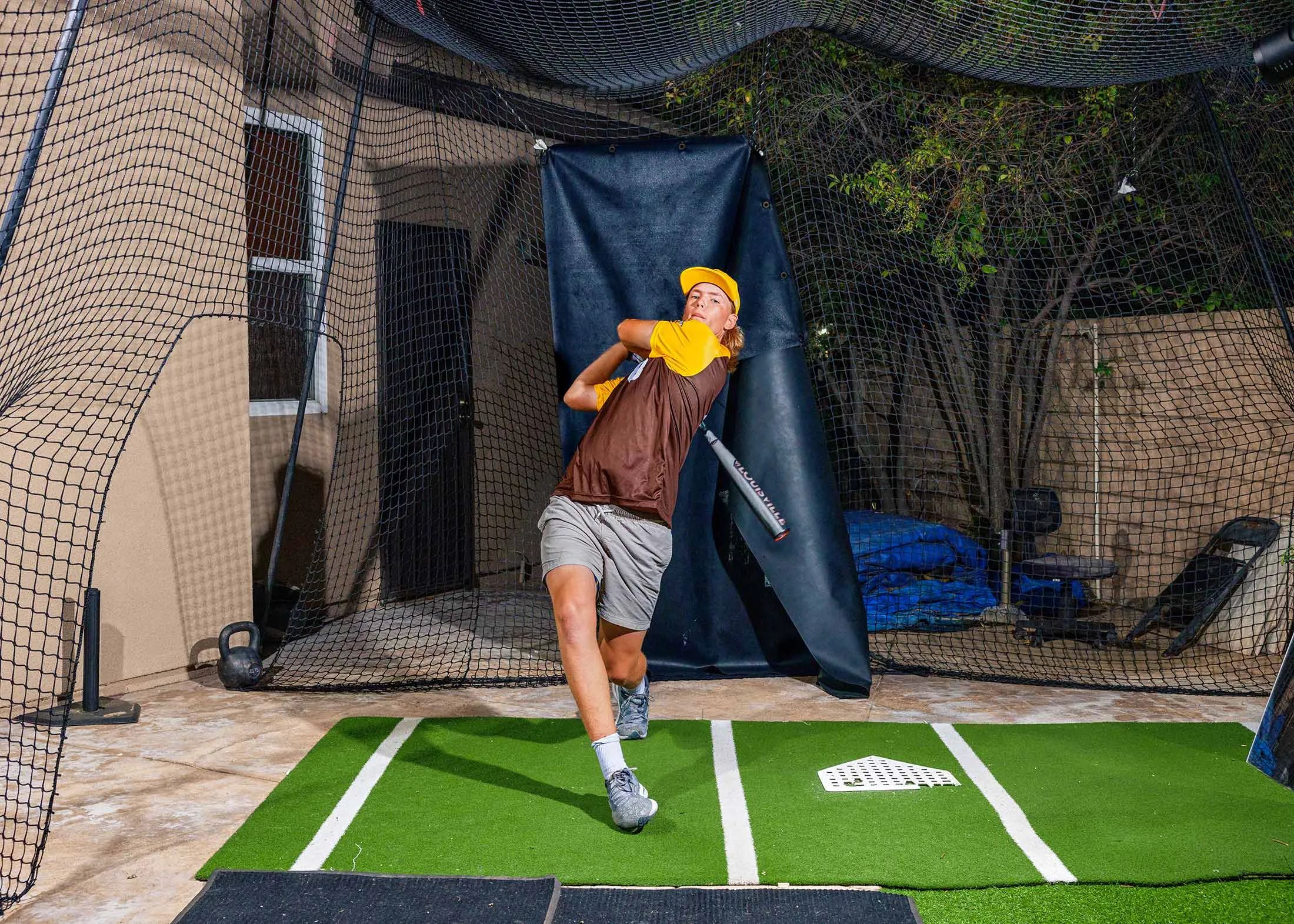 Sixteen-year-old Striker Pence, who is seen as a potential future Major League baseball player, practices in his backyard batting cage in Corona, California.
