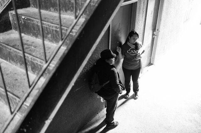 Ovares and co-workers knock on an apartment door at a housing complex. 