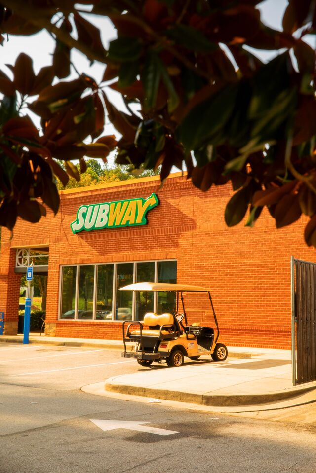 A golf cart parked in golf cart parking outside of a business in Peachtree City