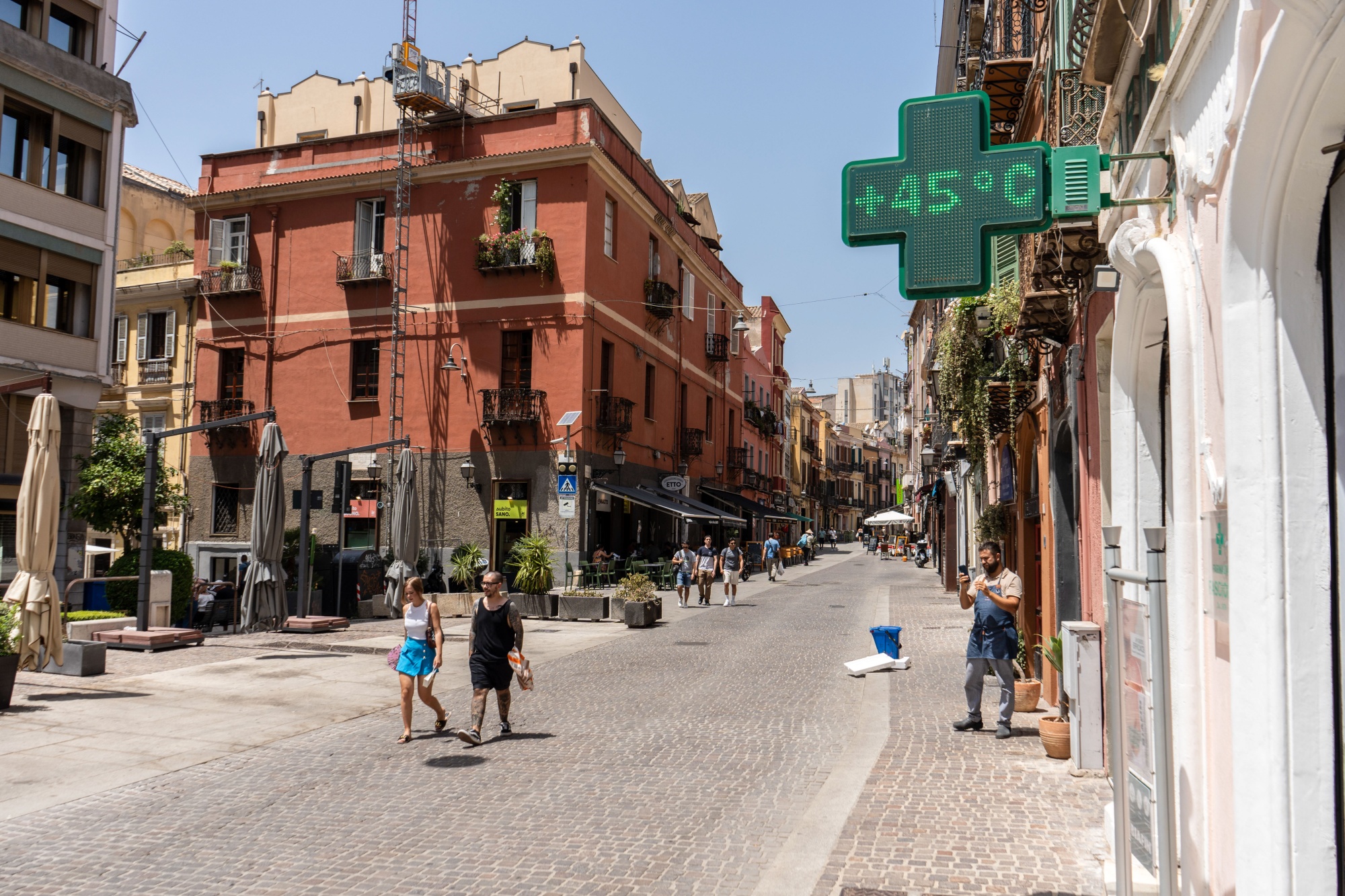 A pharmacy sign displays the temperature on a street in Cagliari, Sardinia