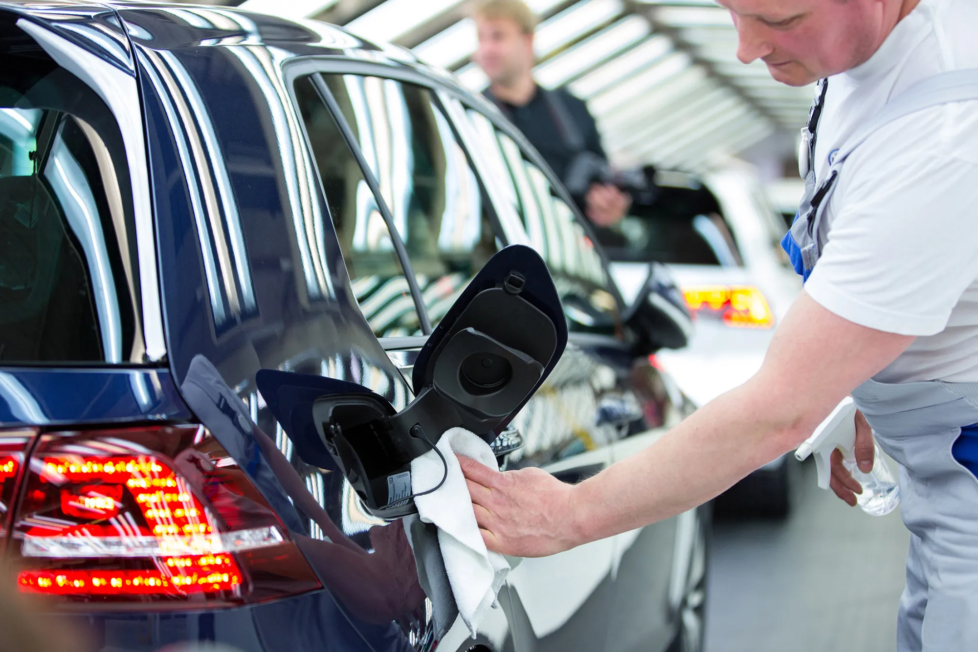 An employee polishes a Volkswagen e-Golf electric automobile inside the Volkswagen AG (VW) factory in Wolfsburg, Germany, on Friday, May 20, 2016. Volkswagen AG agreed to raise German workers' pay after labor leaders vowed that employees wont foot the multi-billion-euro bill to resolve its diesel-emissions scandal.
