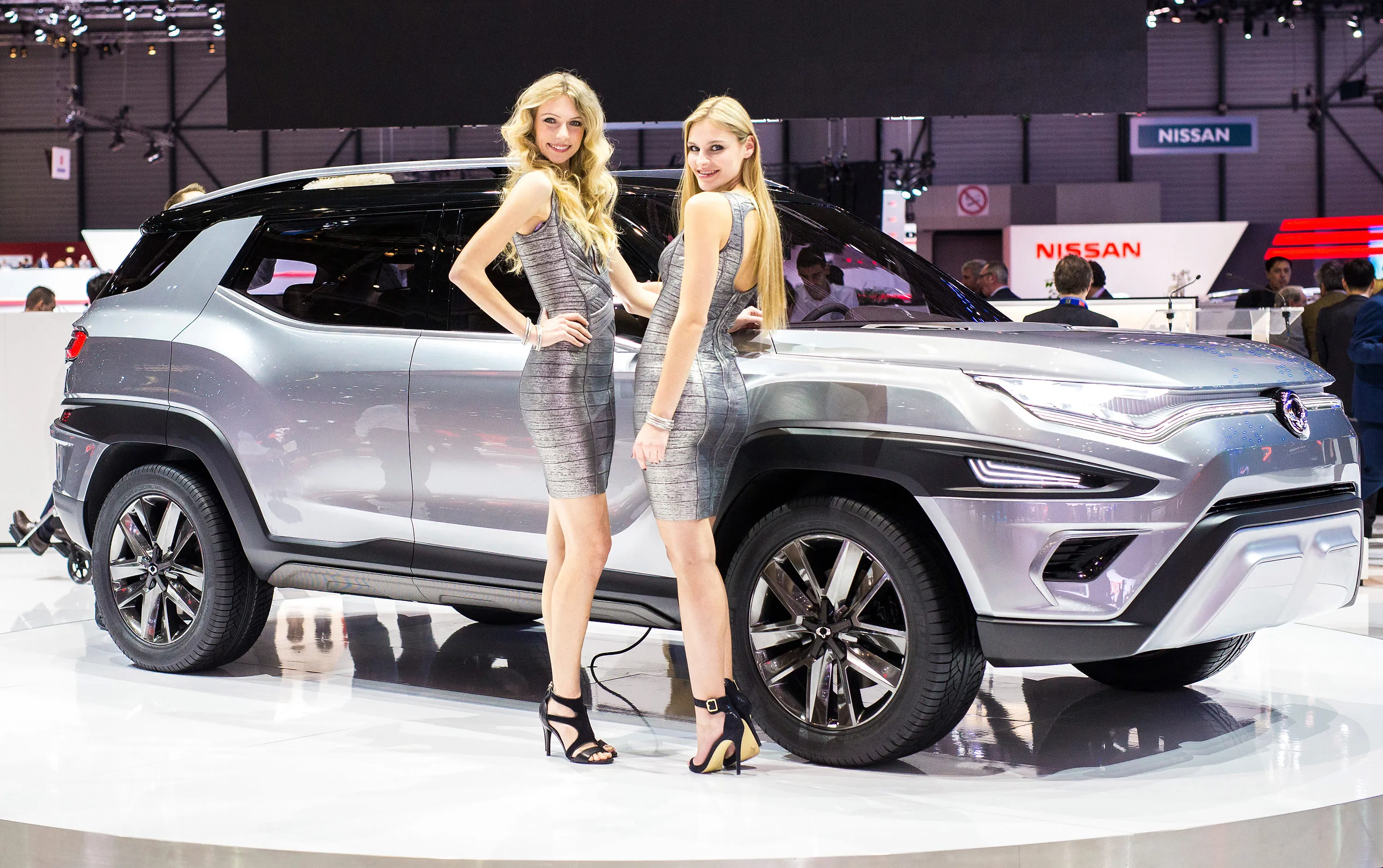 Hostesses stand by a SsangYong XAVL car at the Geneva Motor Show, 2017. 