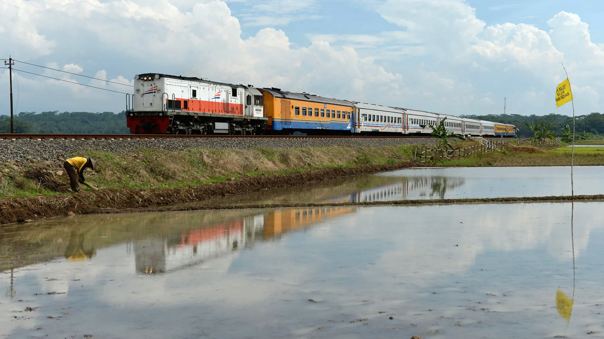 A train passes a rice paddy field on the site of a planned coal-fired power station as a protest flag flies on a pole in Ponowareng village in Batang regency, Central Java province, Indonesia, on Tuesday, April 28, 2015. For President Joko Widodo, a plan to build a $4 billion Japanese-Indonesian coal-fired power station presents a dilemma. He needs the electricity from new plants to power factories that would fuel growth and help rebalance the economy away from natural resources. At the same time, he needs to avoid alienating farmers and poor Indonesians who swept him into office last year.
