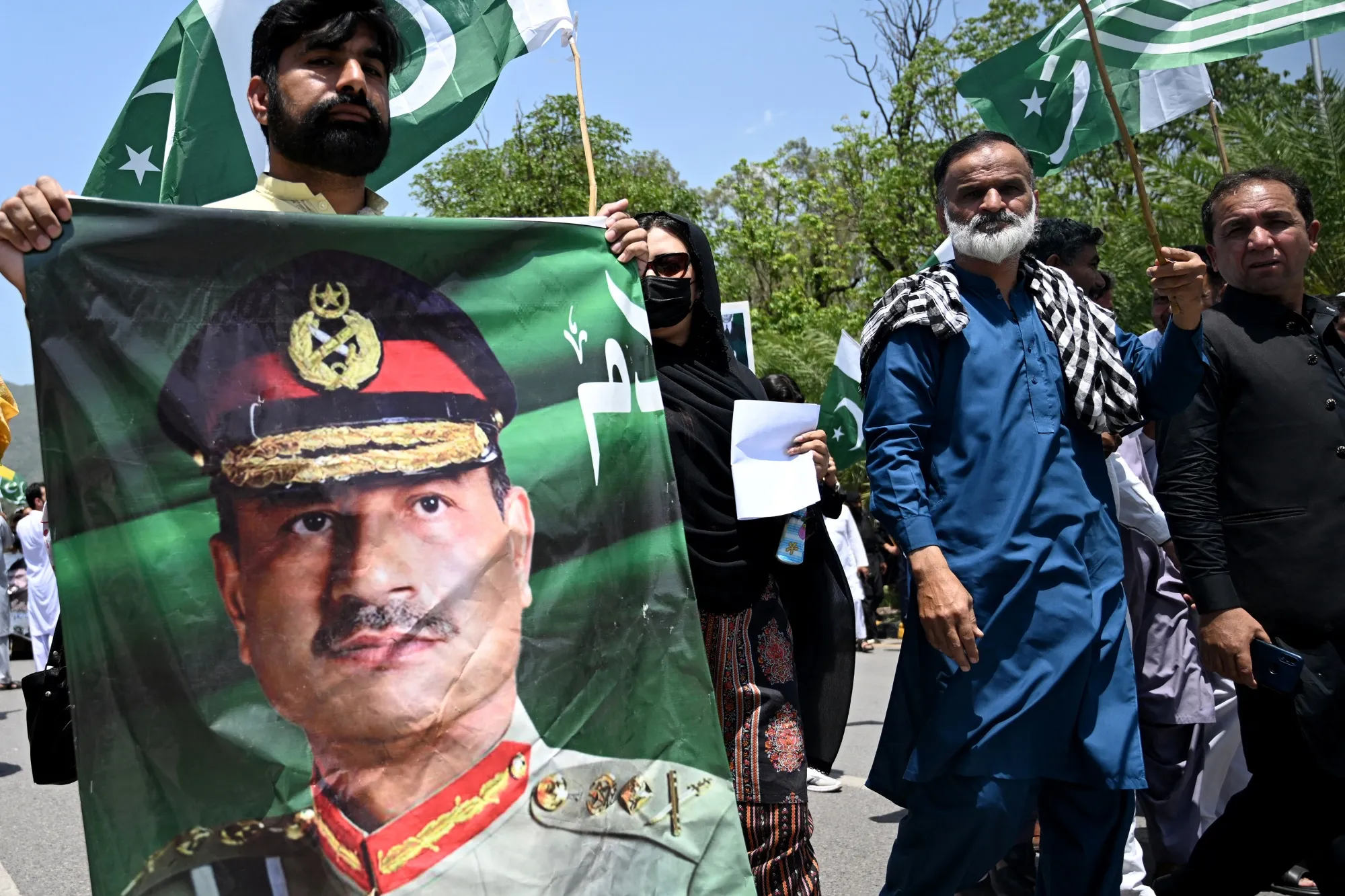 A man carries a portrait of&nbsp;Asim Munir&nbsp;during a rally&nbsp;in Islamabad in May.