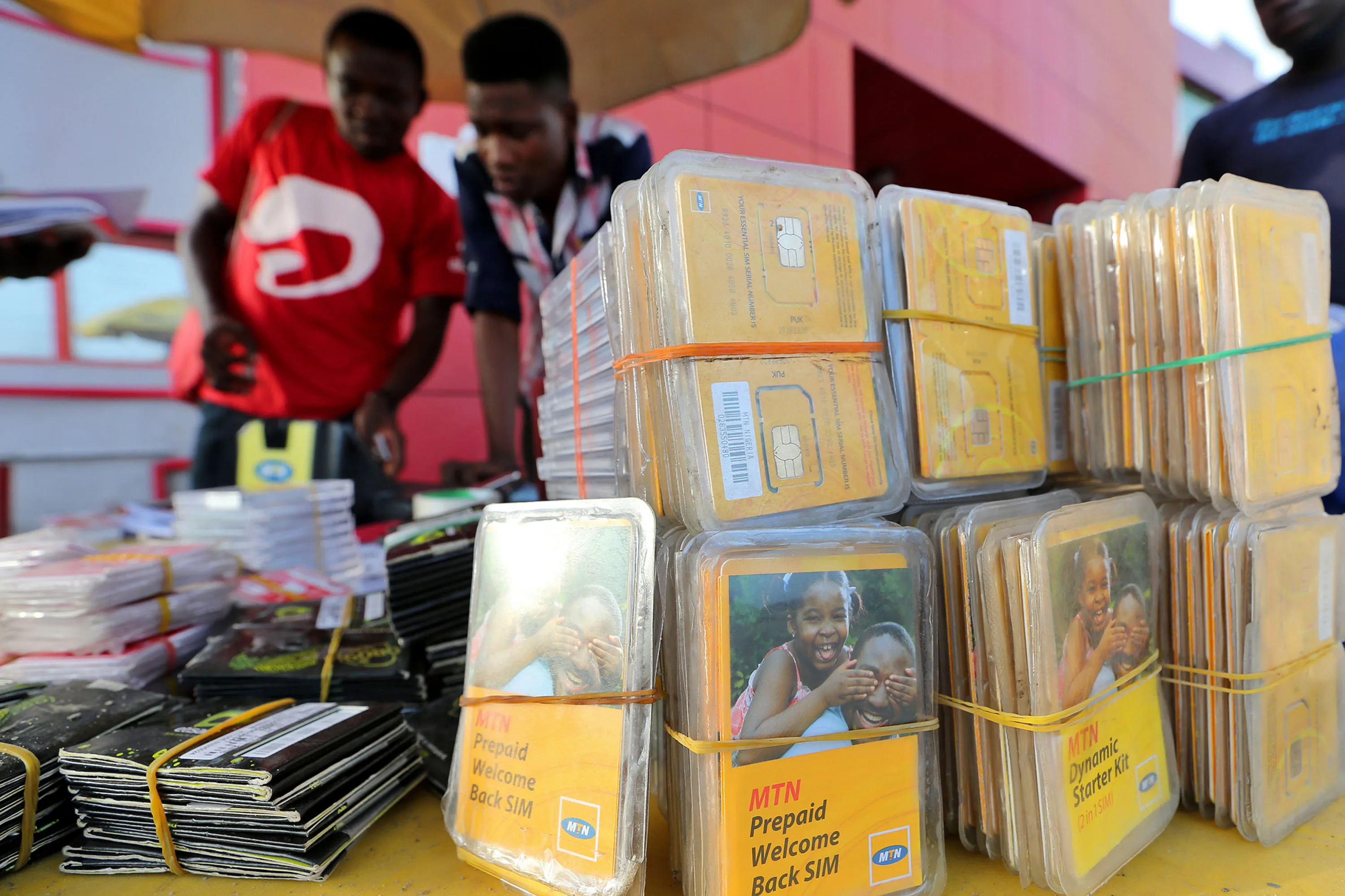 Customers register their MTN Group Ltd. mobile phone sim cards at a roadside kiosk in Lagos.
