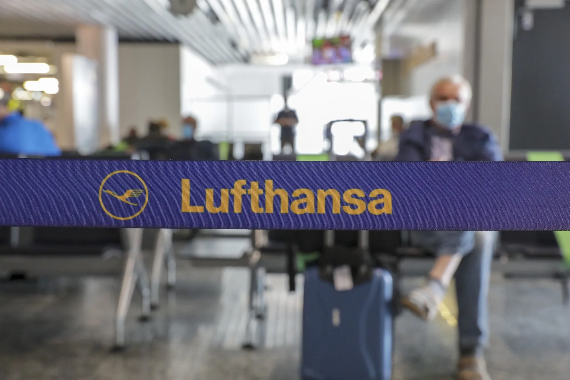 The Deutsche Lufthansa AG logo sits on a departure hall cordon as the airline and airport operator Fraport AG showcase new coronavirus safety measures at Frankfurt Airport in Frankfurt, Germany, on Wednesday, June 17, 2020. Deutsche Lufthansa said a low turnout at its extraordinary general meeting next week is placing its 9 billion-euro ($10 billion) German bailout at risk of falling apart.