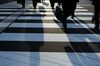 Morning commuters walk across a road in the central business district of Tokyo, Japan, on Jan. 4, 2019. Bloomberg